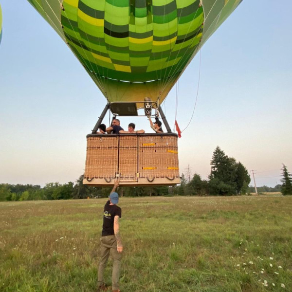Nacelle de la montgolfière quittant le sol avec l'aide de l'équipier