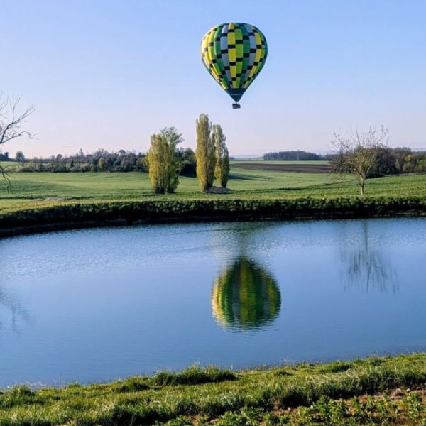 Reflet de la montgolfière sur un lac en phase d'approche pour l'atterrissage